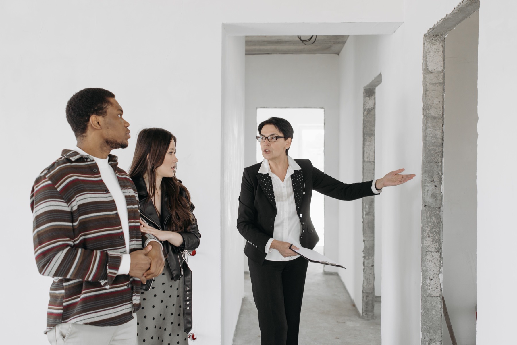 An agent showing a couple around an empty apartment